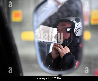 (190203) -- XI AN, 3. Februar 2019 (Xinhua) -- Liefermann Luo Feilong trägt einen Helm, bevor er Pakete in Xi an, der Hauptstadt der nordwestchinesischen Provinz Shaanxi, am 3. Februar 2019 ausliefert. Luo Feilong, ein 31-jähriger Lieferer aus der Provinz Shaanxi, liefert seit vier Jahren Pakete in einer Gemeinde von Xi an. Luo bewarb sich während des diesjährigen Frühlingsfests um Dienstbereitschaft, damit andere Helfer aus der Provinz zu Familientreffen in ihre Heimatorte zurückkehren können. (Xinhua/Zhang Bowen) CHINA-XI AN-SPRING FESTIVAL-DELIVERYMAN (CN) PUBLICATIONxNOTxINxCHN Stockfoto