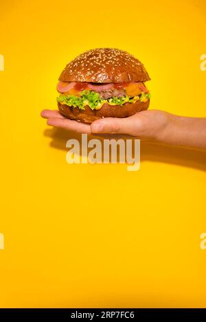 Klassischer Rindfleischburger mit Salat in der Hand Stockfoto