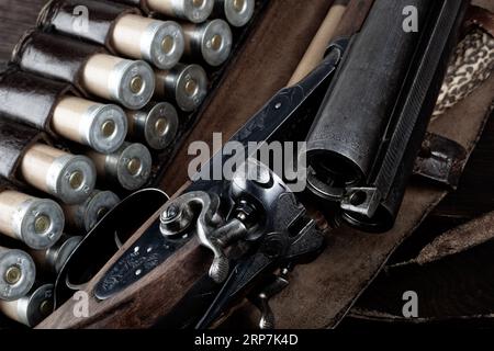 Antike 12-Gauge-Schrotflinte mit glattem Loch und Papierkästen auf Holztisch. Stockfoto