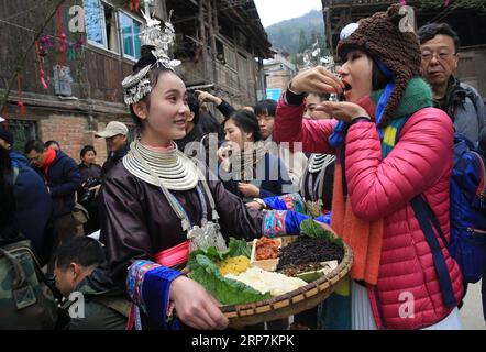 (190208) -- QIANDONGNAN, 8. Februar 2019 (Xinhua) -- Touristen probieren während des Frühlingsfestes im Dorf Dingdong von Qiandongnan Miao und der autonomen Präfektur Dong, Provinz Guizhou im Südwesten Chinas, 8. Februar 2019 traditionelle Speisen der Volksgruppe Dong. (Xinhua/Long Tao) CHINA-GUIZHOU-DONG ETHNISCHE GRUPPE-CHINESISCHES NEUJAHR (CN) PUBLICATIONxNOTxINxCHN Stockfoto