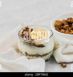Schließen Sie köstlichen Joghurt mit Granola Banane Stockfoto