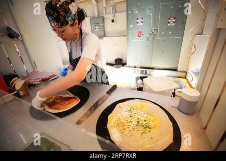 (190211) -- CANBERRA, 11. Februar 2019 (Xinhua) -- Ein Verkäufer macht chinesische Pfannkuchen an einem internationalen Tag auf den Old Bus Depot Markets in Canberra, Australien, am 10. Februar 2019. Das alte Busdepot in Kingston, Australiens Hauptstadt Canberra, hat vor mehr als drei Jahrzehnten die Unterbringung von Bussen eingestellt. Jeden Sonntag ist es jedoch immer noch voller Besucher. Heute ist es der Old Bus Depot Markets, einer der beliebtesten Märkte in Australien. Nach dem chinesischen Neujahrsfest war es Zeuge eines internationalen Tages, der Besucher in verschiedene Kulturen brachte. (Xinhua/Pan Xiangyue) AUSTRALIEN-CANBERRA-ALTES BUSDEPOT Stockfoto