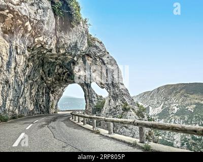 Foto mit reduzierter dynamischer Bereichssättigung HDR-Ansicht der Felsformation mit Durchfahrt auf der Straße Route de Gentelly, Greolieres, Departement Stockfoto