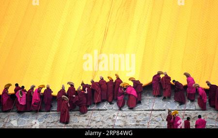 (190218) -- PEKING, 18. Februar 2019 (Xinhua) -- Lamas des Labrang-Klosters Rollen das riesige Thangka-Rollbild auf, das das Bild des Buddha trägt, das von einem großen gelben Vorhang bedeckt ist, während der jährlichen Sonnenaufgang der Buddha-Zeremonie des Labrang-Klosters im Xiahe County, nordwestchinesische Provinz Gansu, 17. Februar 2019. Die jährliche Sonnung des Buddha ist eine der wichtigsten Zeremonien in Labrang im Xiahe County, das als eine der führenden tibetischen buddhistischen Bildungseinrichtungen in China gilt. (Xinhua/Chen bin) XINHUA FOTOS DES TAGES PUBLICATIONxNOTxINxCHN Stockfoto