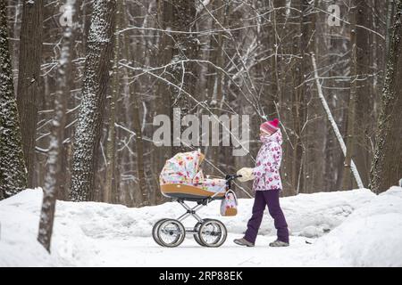 (190221) -- MOSKAU, 21. Februar 2019 -- am 21. Februar 2019 spaziert Eine Frau mit einer Kinderwagen in einem Park in Moskau, Russland. ) RUSSLAND-MOSKAU-SCHNEE AlexanderxZemlianichenkoxJr PUBLICATIONxNOTxINxCHN Stockfoto