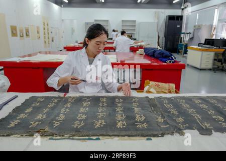 (190223) -- PEKING, 23. Februar 2019 (Xinhua) -- Ein Mitarbeiter repariert eine Kalligraphiesammlung in einem Krankenhaus zur Erhaltung im Palastmuseum in Peking, Hauptstadt von China, 9. Juni 2018. China hat Praktiken zur geschlechtsspezifischen Diskriminierung bei der Einstellung verboten, um die Karrierechancen für Frauen zu verbessern. Laut einem Dokument, das vom Ministerium für Humanressourcen und soziale Sicherheit und anderen acht Regierungsbehörden veröffentlicht wurde, sollten keine Anforderungen an das Geschlecht in Einstellungspläne oder Befragungen aufgenommen werden. Es ist auch verboten, Fragen zum Ehe- oder Fruchtbarkeitsstatus von Kandidatinnen während des Jahres zu stellen Stockfoto