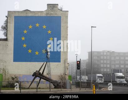 (190223) -- DOVER, 23. Februar 2019 (Xinhua) -- Foto aufgenommen am 22. Februar 2019 zeigt ein gemaltes Wandgemälde des britischen Graffiti-Künstlers Banksy, das einen Arbeiter zeigt, der an einem der Sterne auf einer EU-Flagge in Dover, Großbritannien, abplatzt. (Xinhua/Han Yan) BRITAIN-DOVER-BANKSY-MURAL PUBLICATIONxNOTxINxCHN Stockfoto