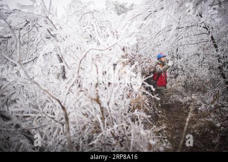 (190223) -- WUHAN, 23. Februar 2019 -- Wan Fei, 40, der Leiter des Inspektionsteams der Wuhan Power Supply Company unter State Grid Corporation, geht durch eine schlammige Straße im Berggebiet von Wuhan, der Hauptstadt der zentralchinesischen Provinz Hubei, 12. Februar 2019. Ein Team von Elektrikern wurde entsandt, um ein Hochspannungskabel zu reparieren, das aufgrund einer dicken Eisschicht gebrochen war. Nach eintägigen Arbeiten an dem über 40 Meter hohen Kraftübertragungsturm bei schlechtem Wetter gelang es dem Team, das gescheiterte Stromsystem zu reparieren, das die Zuggeschwindigkeit senkte und in der Nachhöhzeit Verzögerungen verursachte Stockfoto