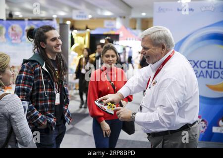 (190226) -- PEKING, 26. Februar 2019 -- Ken Silvestri (1st R), Mitarbeiter von Choo Choo Shoes, zeigt das Produkt des Unternehmens den Besuchern an ihrem Stand während der 116. jährlichen North American International Toy Fair im Jacob K. Javits Convention Center in New York, USA, am 18. Februar 2019. ) Xinhua Schlagzeilen: Mehr lustige Spielzeuge, keine schmerzhaften Zölle: Amerikanische Spielzeugmacher hoffen auf US-China-Handelsabkommen WangxYing PUBLICATIONxNOTxINxCHN Stockfoto