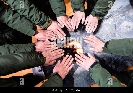 (190227) -- LHASA, 27. Februar 2019 (Xinhua) -- Mitarbeiter der Wildlife Management and Conservation Station wärmen sich die Hände beim Feuer im Shuanghu County, südwestchinesische Autonome Region Tibet, 1. Februar 2019. Shuanghu County, 5.000 Meter über dem Meeresspiegel in der autonomen Region Tibet im Südwesten Chinas, leidet an 200 Tagen im Jahr unter starkem Wind. Mit einer Jahresdurchschnittstemperatur von minus fünf Grad Celsius ist Shuanghu die Heimat des weltweit drittgrößten Gletschers, des Purog Kangri. Gelegentlich sinkt die Temperatur hier auf minus 40 Grad Celsius. Das County, etwa 120.000 Quadratkilometer Stockfoto