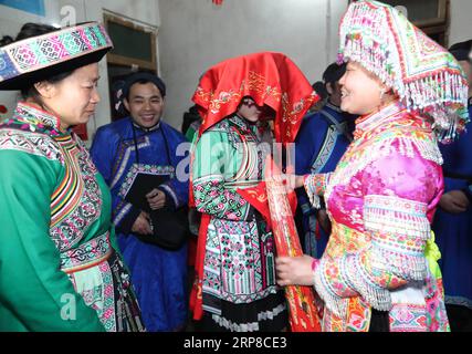 (190227) -- XINGWEN, 27. Februar 2019 (Xinhua) -- Han Yujie (C) ist mit einem roten Brautschleier bedeckt, bevor sie ihr Elternhaus im Xingwen County, südwestchinesische Provinz Sichuan, am 26. Februar 2019 verlässt. Yang Yuqiao und Han Yujie, ein ethnisches Miao-Paar, legten den Knoten im traditionellen Miao-Stil im Wenxing County, der südwestchinesischen Provinz Sichuan, vom 24. Bis 26. Februar 2019 fest. Yang Yuqiao, der 25-jährige Bräutigam, arbeitet als Reiseleiter im Xingwen UNESCO Global Geopark, und Han Yujie, die 23-jährige Braut, arbeitet als PE-Lehrer in der Gemeinde Dahe Miao im Xingwen County. Während der Freiwilligenarbeit von Huashan Festiva Stockfoto