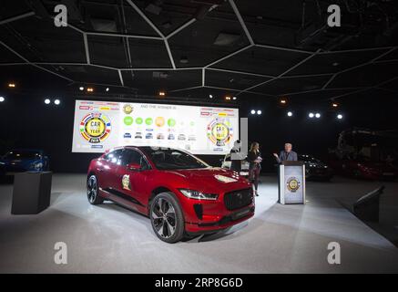 (190304) -- GENF, 4. März 2019 (Xinhua) -- Ian Callum (1. R), Design Director bei Jaguar, hält am 4. März 2019 eine Rede neben einem Jaguar I-PACE auf der Palexpo in Genf, Schweiz. Der erste Elektro-SUV I-PACE von Jaguar gewann am Montag in einem Rundum-Rennen gegen die Alpine A110 am Vorabend des 89. Internationalen Automobilsalon von Genf (GIMS) den „Car of the Year Award“. (Xinhua/Xu Jinquan) SCHWEIZ-GENF-JAGUAR I-PACE-CAR DES JAHRES PUBLICATIONxNOTxINxCHN Stockfoto