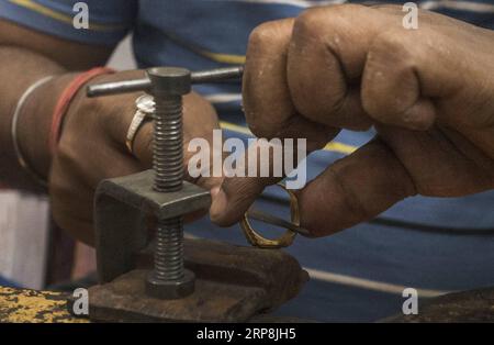 (190308) -- KOLKATA, 8. März 2019 (Xinhua) -- Ein Arbeiter stellt Goldschmuck in einer Werkstatt in Kalkata, Indien, 8. März 2019 her. Die indische Schmuckindustrie spielt eine wichtige Rolle in der Wirtschaft, macht 7 Prozent des BIP und 14 Prozent der Warenexporte aus und stellt 5 Millionen Menschen direkte Arbeitsplätze zur Verfügung. (Xinhua/Tumpa Mondal) INDIEN-KOLKATA-SCHMUCKINDUSTRIE PUBLICATIONxNOTxINxCHN Stockfoto