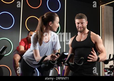 Trainer, der mit Menschen im Fitnessclub arbeitet. Indoor-Radkurs Stockfoto