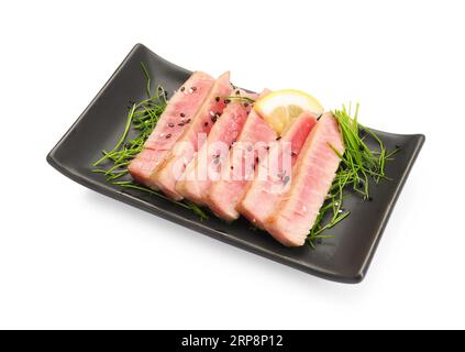 Stücke von köstlichem Thunfischsteak mit Mikrogrün und Zitrone isoliert auf weiß Stockfoto