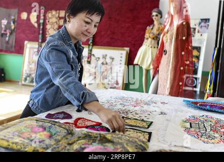 (190313) -- HAMI, 13. März 2019 (Xinhua) -- Renagul arrangiert ihre Stickprodukte am 8. März 2019 in ihrer Werkstatt im Bezirk Yizhou der Hami-Stadt, nordwestchinesische Autonome Region Xinjiang Uygur. Die Haute Couture, wörtlich Blossoming Flower genannt, mit handgefertigten Stickereien mit unverwechselbarem lokalem Geschmack verziert, wurde 2016 auf der Pariser Fashion Week präsentiert. Diese veränderte das Leben der Stickerin Renagul, die nie dachte, dass ihre Werke auf einer weltberühmten Modenschau gezeigt werden würden. Renagul wuchs in einer Stickereifamilie in Hami auf. Von ihrer Mutter beeinflusst, stickt sie gerne Stockfoto