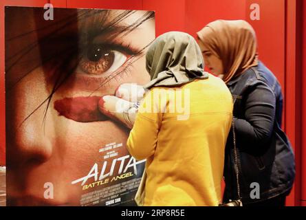 (190313) -- BAGDAD, 13. März 2019 (Xinhua) -- Foto aufgenommen am 21. Februar 2019 zeigt zwei irakische Frauen neben einem Filmplakat in einem Kino in Bagdad, Irak. ZU DEN Features: Moderne Kinos MIT mehreren Bildschirmen ziehen begeisterte irakische Kinobesucher an, während die berühmten Kinos (Xinhua/Khalil Dawood) IRAK-BAGDAD-KINO PUBLICATIONxNOTxINxCHN verschwinden Stockfoto