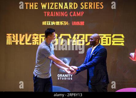 (190318) -- PEKING, 18. März 2019 (Xinhua) -- NBA-Legende Kobe Bryant (R) rüttelt Hand mit dem chinesischen Basketballspieler Yi Jianlian während der Kobe-Konferenz zur gemeinsamen Nutzung von Büchern in einer Mittelschule in Shenzhen, Provinz Guangdong, am 17. März 2019. Kobe interagierte mit Schülern, darunter auch mit Kindern, die mit dem Kobe China Fund in Verbindung gebracht wurden, und teilte am Sonntag seinen neuen Sportfantasieroman „The Wizenard Series: Training Camp Here“. (Xinhua/Mao Siqian) XINHUA FOTOS DES TAGES PUBLICATIONxNOTxINxCHN Stockfoto