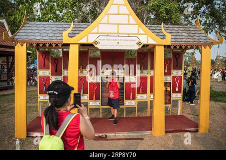 (190318) -- AYUTTHAYA, 18. März 2019 (Xinhua) -- Ein Mann posiert für ein Foto mit Mongkons während der 15. World Wai Kru Muay Thai Zeremonie in Ayutthaya, Thailand, 17. März 2019. Die Zeremonie, die jährlich im Ayutthaya Historical Park stattfindet, bietet Hunderten von Muay Thai-Praktizierenden aus der ganzen Welt die Möglichkeit, ihren Meistern in der altehrwürdigen Tradition, der sogenannten Wai Kru-Zeremonie, ihren Dank auszusprechen. und um die alte Kampfkunst Muay Thai zu feiern. (Xinhua/Zhang Keren) (SP)THAILAND-AYUTTHAYA-MUAY THAI-CEREMONY PUBLICATIONxNOTxINxCHN Stockfoto