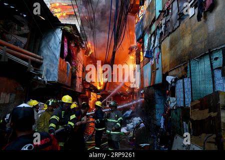 (190321) -- PEKING, 21. März 2019 -- Feuerwehrleute versuchen, ein Feuer in einem Slum-Gebiet in Quezon City, Philippinen, 20. März 2019, auszulöschen. Mehr als 250 Shanties wurden im Feuer zerstört, wodurch 750 Familien obdachlos wurden. ) XINHUA-FOTOS DES TAGES ROUELLExUMALI PUBLICATIONxNOTxINxCHN Stockfoto