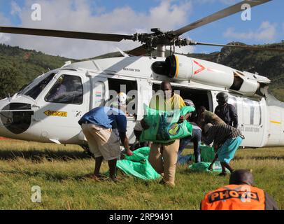 Simbabwe, Schäden nach Zyklon Idai (190322) -- CHIMANIMANI (SIMBABWE), 22. März 2019 -- Arbeiter entladen gespendete Lebensmittel aus einem Hubschrauber in Chimanimani, Provinz Manicaland, Simbabwe, 22. März 2019. Der simbabwische Präsident Emmerson Mnangagwa hat am Donnerstag zwei Tage nationaler Trauer nach dem verheerenden Zyklon Idai erklärt, der 139 Menschen getötet und im Osten und Süden des Landes eine Spur der Zerstörung hinterlassen hat. Während die Rettungs- und Suchbemühungen fortgesetzt werden, fließen Hilfsgüter von den lokalen Menschen, Unternehmen, regionalen Regierungen und an die Opfer weiter Stockfoto