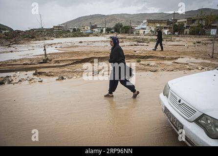 (190327) -- SHIRAZ, 27. März 2019 -- Eine Frau geht im Schlamm nach einer Überschwemmung durch starke Regenfälle in Shiraz, Süd-Iran, 26. März 2019. Mindestens 25 Menschen wurden bei den schweren Regenfällen und den nachfolgenden Überschwemmungen in der vergangenen Woche im Iran getötet. ) IRAN-SHIRAZ-FLOOD-AFTERMATH AhmadxHalabisaz PUBLICATIONxNOTxINxCHN Stockfoto