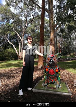 (190329) -- CANBERRA, 29. März 2019 (Xinhua) -- die Koordinatorin für Gartenbesuchererfahrung Megan Donaldson steht neben einer Koala-Statue im Australian National Botanic Gardens in Canberra, Australien, 28. März 2019. 14 ein Meter hohe Koala-Statuen, die von verschiedenen Künstlern dekoriert wurden, sind über die Australian National Botanic Gardens verteilt und können vom 1. Bis 31. März auf dem Boden von Besuchern entdeckt werden, die Geschichten hinter sich haben. Megan Donaldson, die Koordinatorin der Gartenbesuchererfahrung, sagte, dass die Pop-up-Statuen darauf abzielen, das Bewusstsein für australische Pflanzen und einheimische Tiere zu schärfen. (Xinhu Stockfoto