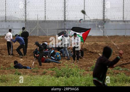 (190330) -- GAZA, 30. März 2019 () -- palästinensische Demonstranten treffen mit israelischen Truppen an der Grenze zwischen Gaza und Israel, östlich von Gaza-Stadt, 30. März 2019. Mindestens drei Palästinenser wurden am Samstag bei einem tagelangen Zusammenstoß mit israelischen Soldaten im östlichen Gazastreifen nahe der Grenze zu Israel getötet und 316 verletzt, sagten Mediziner. Die heftigen Zusammenstöße markierten den ersten Jahrestag der Kundgebungen, besser bekannt als der große Rückkehrmarsch, und auch 43 Jahre für den Tag des palästinensischen Landes. () MIDEAST-GAZA-KONFLIKTE Xinhua PUBLICATIONxNOTxINxCHN Stockfoto