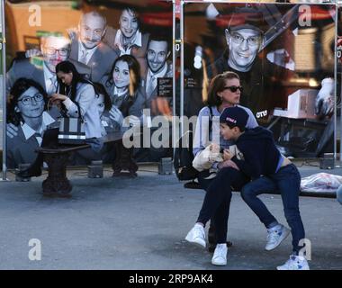(190331) -- PARIS, 31. März 2019 (Xinhua) -- Touristen ruhen sich in einem Bereich einer Fotoshow aus, die den Menschen gewidmet ist, die am 30. März 2019 für den Eiffelturm in Paris arbeiten. Eine Reihe von Veranstaltungen, darunter Aufführungen, Fotoshows und Abenteuerspiele, werden ab März 30 stattfinden, um das 130-jährige Bestehen des Eiffelturms zu feiern. (Xinhua/Gao Jing) FRANKREICH-PARIS-EIFFELTURM-130 Jahre PUBLICATIONxNOTxINxCHN Stockfoto