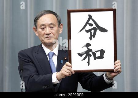 (190401) -- TOKIO, 1. April 2019 (Xinhua) -- Japans Kabinettssekretär Yoshihide Suga hält ein gerahmtes Bild von Reiwa, dem Namen der neuen Ära Japans, während einer Pressekonferenz in Tokio, Japan, am 1. April 2019. Die japanische Regierung gab am Montag bekannt, dass Reiwa der Name der neuen Ära Japans sein wird, die am 1. Mai beginnen wird, als Kronprinz Naruhito den Chrysanthemen-Thron als Nachfolger seines Vaters Kaiser Akihito bestiegen wird. Der Name der neuen Ära, bestehend aus zwei chinesischen Schriftzeichen, die grob übersetzt für geordnet oder verheißungsvoll und Frieden oder Harmonie stehen, leitet sich von man yoshu ab, der ältesten Anthologie o Stockfoto