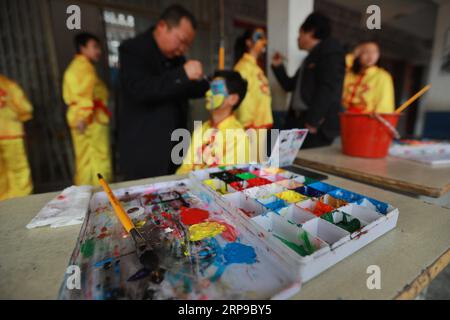 (190402) -- JINPING, 2. April 2019 (Xinhua) -- Lehrer malen die Gesichter von Schülern in Vorbereitung auf den Drachentanz in der Longli Mittel- und Grundschule im Jinping County, Provinz Guizhou im Südwesten Chinas, am 20. März 2019. Longlis Drachentanz wurde 2005 als immaterielles Kulturerbe der Provinz Guizhou klassifiziert und hat eine Geschichte von mehr als 600 Jahren. Es zeichnet sich durch das schöne Gesicht der Tänzer aus. Seit 2008 wird Longlis Drachentanz in die Longli Mittel- und Grundschule eingeführt, deren Schüler zwei Stunden pro Woche mit Drachentanzmeistern Kostüme lernen Stockfoto