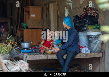 (190402) -- PHNOM PENH, 2. April 2019 (Xinhua) -- Summe Meyle ernährt ihre Tochter, nachdem sie eine Katarakt-Operation im Kampong Cham Provincial Hospital in Kampong Cham, Kambodscha, am 15. März 2019 erhalten hat. Sum Meyle, 36, ist eine alleinerziehende Mutter mit fünf Kindern. Um ihre finanziellen Bedingungen zu verbessern, arbeiten zwei von Meyles Töchtern jetzt in der Hauptstadt Phnom Penh, während zwei ihrer Söhne in einem Kinderheim leben. MEYLE lebt heute mit ihrer jüngsten Tochter in einem gemieteten Shanty House. MEYLE hatte an Katarakt gelitten, nachdem ihr linkes Auge verletzt worden war. Vor sieben Monaten hatte sie ihr e fast verloren Stockfoto