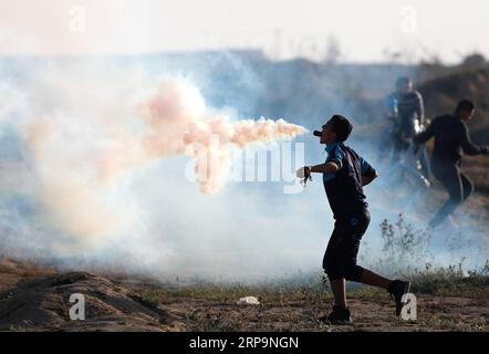 Nachrichten Themen der Woche KW15 190412 -- GAZA, 12. April 2019 -- Ein palästinensischer Demonstrant hält einen Tränengaskanister in seinem Mund, der von israelischen Truppen während der Zusammenstöße an der Grenze zwischen Gaza und Israel, östlich des Flüchtlingslagers al-Bureij im Zentrum von Gaza, am 12. April 2019 gefeuert wurde. Die israelische Armee erschoss am Freitag einen palästinensischen Jungen und verwundete Dutzende bei Zusammenstößen mit Hunderten palästinensischer Demonstranten im östlichen Gazastreifen, nahe der Grenze zu Israel, laut Ärzten. MIDEAST-GAZA-KONFLIKTE YasserxQudih PUBLICATIONxNOTxINxCHN Stockfoto