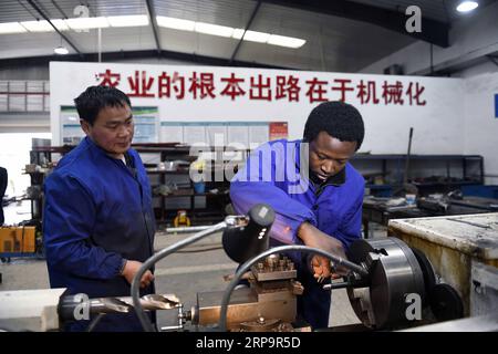 (190415) -- CHANGSHA, 15. April 2019 (Xinhua) -- Mangeh III Fondzenyuy Cedric (R) lernt an der Hunan Agricultural University in Changsha, der zentralchinesischen Provinz Hunan, am 14. März 2019 den Betrieb eines Werkzeugmaschinenwerkzeugs. Der 25-jährige Cedric kommt aus Kamerun. Nachdem er Zeuge chinesischer Unternehmen war, die Agrarwissenschaften und -Technologie und -Ausrüstung weiterentwickelten, kam er 2017 nach China und studierte nach Abschluss seines Grundstudiums als Postgraduierter in Landwirtschaftstechnik an der School of Engineering der Hunan Agricultural University. Cedric studiert hauptsächlich landwirtschaftliche Mechanik Stockfoto