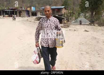 (190415) -- SURKHET, 15. April 2019 -- Lila RAM Acharya bringt Mittagessen zu den Arbeitern auf der Baustelle des Tunnels für das Bheri Babai Diversion Multipurpose Project in Surkhet, West-Nepal, 26. März 2019. Der sechsundvierzigjährige Lila RAM Acharya begann vor zwei Jahren im Bheri Babai Diversion Multipurpose Project zu arbeiten und seine Frau führte ein Hotel, um den Projektarbeitern Essen zu servieren. Das Ehepaar ist gut besiedelt und wirtschaftlich von dem in China errichteten Projekt profitiert. ZUM Feature: Chinesisches Bewässerungsprojekt hilft der Landwirtschaft, bietet Arbeitsplätze in Nepal ) NEPAL-SURKHET-BEWÄSSERUNG Stockfoto