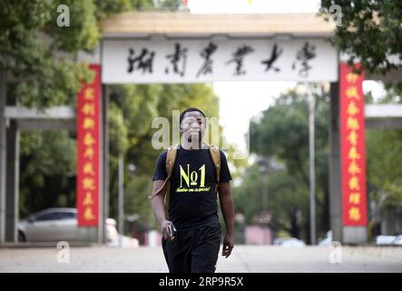 (190415) -- CHANGSHA, 15. April 2019 (Xinhua) -- Mangeh III Fondzenyuy Cedric wird am Eingang der Hunan Agricultural University in Changsha, der zentralchinesischen Provinz Hunan, am 19. März 2019 gesehen. Der 25-jährige Cedric kommt aus Kamerun. Nachdem er Zeuge chinesischer Unternehmen war, die Agrarwissenschaften und -Technologie und -Ausrüstung weiterentwickelten, kam er 2017 nach China und studierte nach Abschluss seines Grundstudiums als Postgraduierter in Landwirtschaftstechnik an der School of Engineering der Hunan Agricultural University. Cedric studiert hauptsächlich landwirtschaftliche Mechanisierung und aut Stockfoto