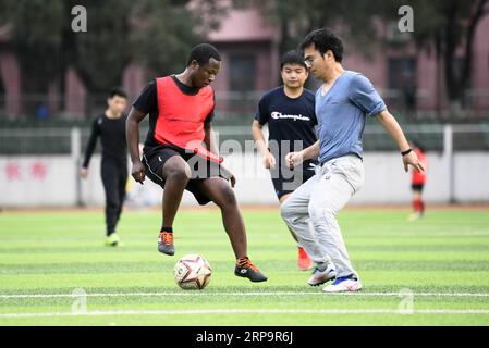 (190415) -- CHANGSHA, 15. April 2019 (Xinhua) -- Mangeh III Fondzenyuy Cedric (L) spielt Fußball mit Schulkameraden an der Hunan Agricultural University in Changsha, Provinz Hunan in Zentralchina, 19. März 2019. Der 25-jährige Cedric kommt aus Kamerun. Nachdem er Zeuge chinesischer Unternehmen war, die Agrarwissenschaften und -Technologie und -Ausrüstung weiterentwickelten, kam er 2017 nach China und studierte nach Abschluss seines Grundstudiums als Postgraduierter in Landwirtschaftstechnik an der School of Engineering der Hunan Agricultural University. Cedric studiert hauptsächlich landwirtschaftliche Mechanik Stockfoto