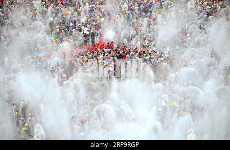 (190415) -- XISHUANGBANNA, 15. April 2019 -- Menschen feiern das Wassersprühfest auf einem Platz in Jinghong, Dai Autonome Präfektur Xishuangbanna, südwestchinesische Provinz Yunnan, 15. April 2019. Die Menschen streuen Wasser aufeinander, um während des traditionellen Wassersprühfestivals für Glück zu beten, das auch das Neujahrsfest der Dai-ethnischen Gruppe ist. Qin Qing) CHINA-YUNNAN-XISHUANGBANNA-WATER SPROSSING FESTIVAL (CN) Qinqing PUBLICATIONxNOTxINxCHN Stockfoto