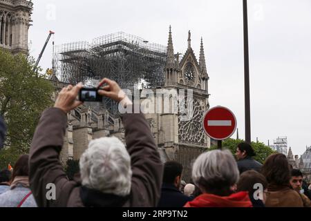 (190417) -- PARIS, 17. April 2019 (Xinhua) -- Menschen drängen sich auf der Straße vor der Kathedrale Notre Dame nach einem Brand in Paris, Frankreich, am 16. April 2019. Der französische Präsident Emmanuel Macron versprach am Dienstag, innerhalb von fünf Jahren die Kathedrale Notre Dame, die am Montagabend vom Feuer verwüstet wurde, wieder aufzubauen und forderte die Franzosen auf, vereint zu bleiben. Am frühen Montagabend brach in der berühmten Kathedrale ein Feuer aus. Online-Aufnahmen zeigten dicken Rauch, der von der Spitze der Kathedrale wehte, und riesige Flammen zwischen ihren beiden Glockentürmen, die den Turm und das gesamte Dach umschlossen, die beide später zusammenbrachen. (Xinhua/Ga Stockfoto