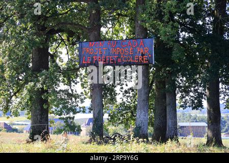 Banderoles et panneaux d’opposition à l’implation d’un Centre d’accueil de demandeurs d’asile (CADA) dans la petite commune rurale de Beyssenac e Stockfoto