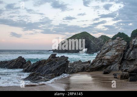 Sonnenuntergang am touristischen Zipolite Beach in Oaxaca, Mexiko. Felsiger Strand ohne Leute. Stockfoto