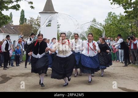 (190423) -- SZENTENDRE, 23. April 2019 -- lokale junge Männer spritzen Frauen im Rahmen der traditionellen Folklore-Osterfeier während einer Presseveranstaltung im ethnografischen Freilichtmuseum Skanzen in Szentendre, Ungarn, am 22. April 2019 mit Wasser zu. ) UNGARN-SZENTENDRE-OSTERTRÄNKE AttilaxVolgyi PUBLICATIONxNOTxINxCHN Stockfoto