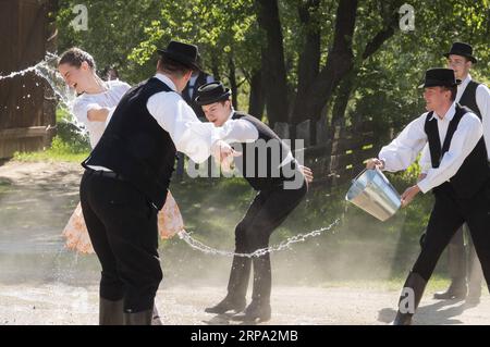 (190423) -- SZENTENDRE, 23. April 2019 -- lokale junge Männer spritzen Frauen im Rahmen der traditionellen Folklore-Osterfeier während einer Presseveranstaltung im ethnografischen Freilichtmuseum Skanzen in Szentendre, Ungarn, am 22. April 2019 mit Wasser zu. ) UNGARN-SZENTENDRE-OSTERTRÄNKE AttilaxVolgyi PUBLICATIONxNOTxINxCHN Stockfoto