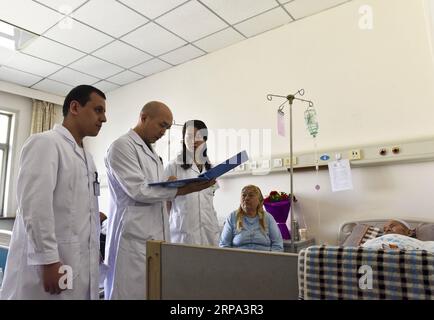 (190424) -- PEKING, 24. April 2019 (Xinhua) -- Radzhabov Alisher (1. L) überprüft den Zustand eines Patienten mit seinem Vorgesetzten (2. L) und Kollegen in einem Krankenhaus für traditionelle chinesische Medizin in der nordwestchinesischen Autonomen Region Xinjiang Uygur, 13. April 2017. Radzhabov Alisher aus Tadschikistan ist ein 29-jähriger Student an der Medizinischen Universität Xinjiang. Er studierte Akupunktur als Student und wurde im September 2016 als Student zugelassen. Als Assistenzarzt im Krankenhaus, während er für seinen Master-Abschluss arbeitete, schaffte es Alisher, TCM zu machen, dessen TV-Programme einst ama waren Stockfoto