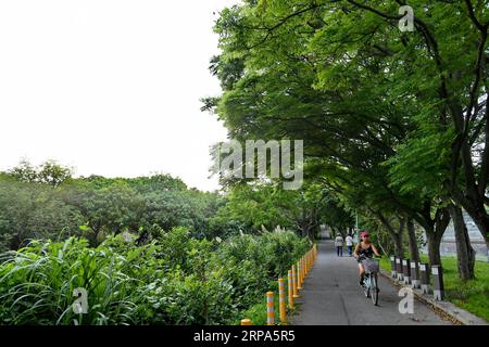 (190426) -- TAIPEI, 26. April 2019 (Xinhua) -- Menschen werden gesehen, wie sie entlang des Tamsui-Flusses im Südostchinesischen Taiwan, 25. April 2019, wandern oder Radfahren. (Xinhua/Zhang Guojun) CHINA-TAMSUI RIVER-LANDSCHAFT (CN) PUBLICATIONxNOTxINxCHN Stockfoto