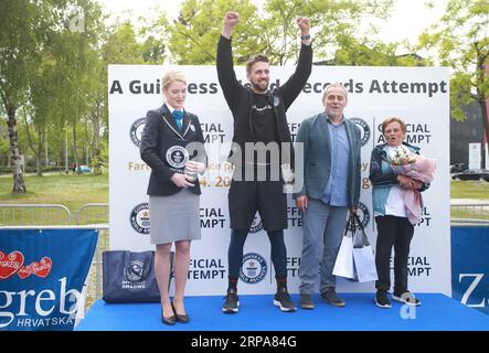 (190428) -- ZAGREB, 28. April 2019 -- Tomislav Lubenjak (2. L) feiert, nachdem er den Guinness-Weltrekord gebrochen hat, weil er ein Auto am weitesten in 24 Stunden von einem Individuum in Zagreb, Kroatien, am 28. April 2019 geschoben hat. Lubenjak startete am Samstag um 15 Uhr und hielt am Sonntag um etwa 14:20 Uhr an, nachdem er das Smart Car mit einem Fahrer 106,938 Kilometer lang im Inneren geschoben hatte. ) KROATIEN-ZAGREB-GUINNESS WELTREKORDWAGEN, DER MATIJAXHABLJAK PUBLICATIONXNOTXINXCHN SCHIEBT Stockfoto
