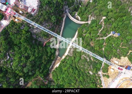 (190504) -- PEKING, 4. Mai 2019 (Xinhua) -- Luftaufnahme, aufgenommen am 3. Mai 2019, zeigt Touristen, die auf einer Glasbrücke auf dem Changshou-Berg in der Zhulin-Gemeinde Gongyi, der zentralchinesischen Provinz Henan, spazieren. In den letzten Jahren hat sich Zhulin Township der Entwicklung der Tourismusbranche verschrieben, um das Einkommen der Menschen zu steigern. (Xinhua/Feng Dapeng) XINHUA FOTOS DES TAGES PUBLICATIONxNOTxINxCHN Stockfoto