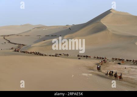 (190506) -- PEKING, 6. Mai 2019 (Xinhua) -- Touristen reiten am 1. Mai 2019 auf Kamelen in der Crescent Spring and Mingsha Sand Dune Scenic Area in Dunhuang, nordwestchinesische Provinz Gansu. Touristen verzeichneten während des Maiurlaubs von Mittwoch bis Samstag 195 Millionen Inlandsreisen in China, was einem Anstieg von 13,7 Prozent im Jahresvergleich entspricht. Und die Tourismuseinnahmen stiegen in den letzten vier Tagen um 16,1 Prozent auf 117,7 Milliarden Yuan (etwa 17,5 Milliarden US-Dollar), laut Schätzungen des Ministeriums für Kultur und Tourismus. Große Online-Reiseplattformen haben auch Trends bei der Verbesserung des Tourismus beobachtet. T Stockfoto