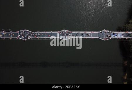 (190506) -- PEKING, 6. Mai 2019 (Xinhua) -- Luftaufnahme, aufgenommen am 1. Mai 2019, zeigt Touristen, die auf der Glasbrücke in der Gemeinde Wanda im Danzhai County in Qiandongnan Miao und der autonomen Präfektur Dong in der südwestchinesischen Provinz Guizhou spazieren. Touristen verzeichneten während des Maiurlaubs von Mittwoch bis Samstag 195 Millionen Inlandsreisen in China, was einem Anstieg von 13,7 Prozent im Jahresvergleich entspricht. Und die Tourismuseinnahmen stiegen in den letzten vier Tagen um 16,1 Prozent auf 117,7 Milliarden Yuan (etwa 17,5 Milliarden US-Dollar), laut Schätzungen des Ministeriums für Kultur und Tourismus. Große Online-Reisen Stockfoto