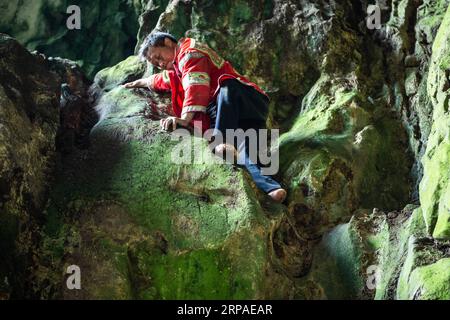 (190506) -- ZIYUN, 6. Mai 2019 (Xinhua) -- Foto aufgenommen am 19. April 2019 zeigt die Klippe spiderman Huang Xiaobao, die eine steile Klippe am Getu River hoch kriecht. Luo Dengping aus der Miao-Ethnie, 38, konnte in 20 Minuten auf einer 80 Meter hohen Klippe ohne Hilfsmittel und ohne Schutz in der malerischen Gegend des Getu River ein freies hin- und herklettern. Fünf weitere Klippenspinnen wie Luo spielen zweimal bis fünf Mal am Tag ein kostenloses Solo für die Touristen. (Xinhua/Tao Liang) CHINA-GUIZHOU-ANSHUN-FREIES KLETTERN- Stockfoto